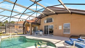 A pool area with a covered patio, lounge chairs, and a table with chairs. - Aviana Resort - Lovely 4bd/3ba Pool Home - #4av141 (Davenport)