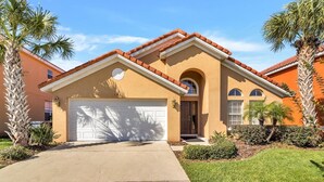 A two-story house with a beige facade, a red-tiled roof, and a white garage door. - Aviana Resort - Lovely 4bd/3ba Pool Home - #4av141 (Davenport)