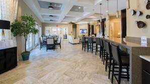 Eine Hotlellobby mit Empfangstresen, Sitzgelegenheiten und einer Bar.
