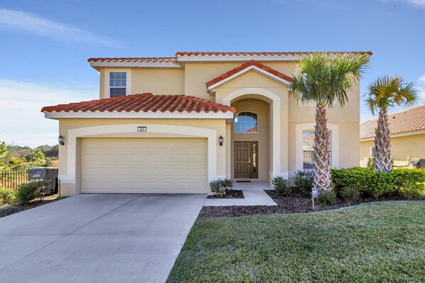 A two-story house with a garage, a front door, and a small porch.