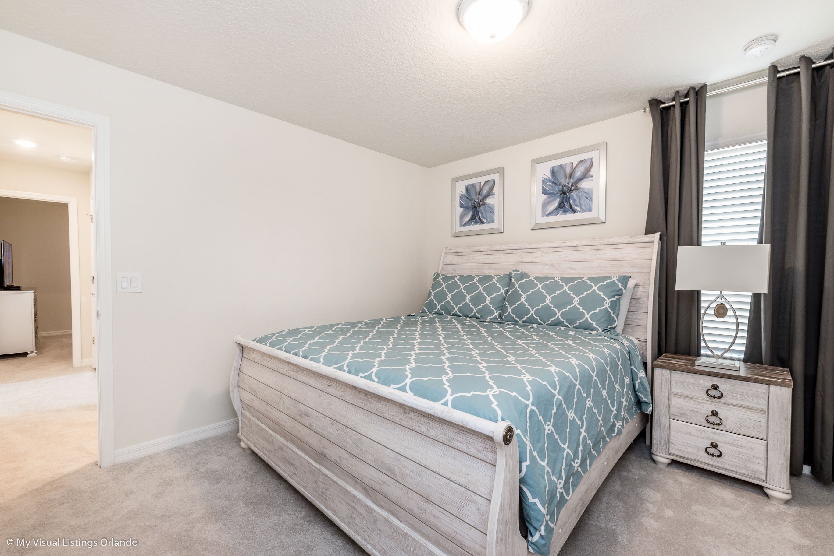 A bedroom with a bed, a nightstand, and a dresser.
