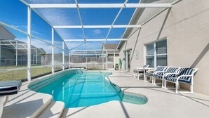 A covered outdoor swimming pool with lounge chairs and a pergola structure. - Hampton Lakes - Spacious 4bd/2ba Pool Home #4hl510 (Davenport)