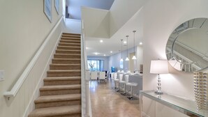 A modern interior with a staircase leading to a dining area. - Solterra Resort 7BD Brand New Pool Home #7st565 (Davenport)