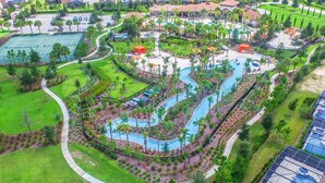 An aerial view of a resort with a winding pool, tennis courts, and lush landscaping. - Solterra Resort 7BD Brand New Pool Home #7st565 (Davenport)