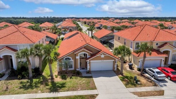 A residential area with houses featuring red-tiled roofs and a central driveway.