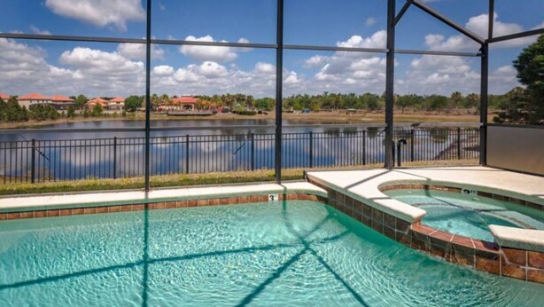A swimming pool with a view of a lake and buildings in the background.