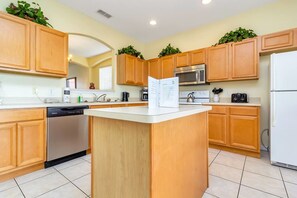 Enjoy cooking in this well-equipped kitchen with a central island, sink, and appliances.