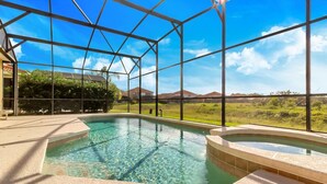 An indoor swimming pool with clear water, surrounded by a glass enclosure, and a view of a suburban landscape. - Davenport-6bd/5.5ba Pet-friendly Poolhome-#6av206 (Davenport)