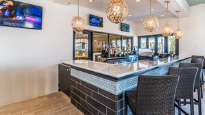 A bar area with a counter, bar stools, and hanging pendant lights. - Brand New Luxurious Pool Home in Westside! 5bd/4ba #5ws690 (Kissimmee)