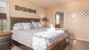 A bedroom with a large bed, a nightstand, a dresser, and a mirror on the wall. - Marbella South - Lovely 5bd/3.5ba PH #5ms040 (Davenport)