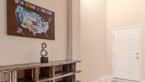 A hallway with a wooden bench, a wall-mounted map, and a white door. - Marbella South - Lovely 5bd/3.5ba PH #5ms040 (Davenport)
