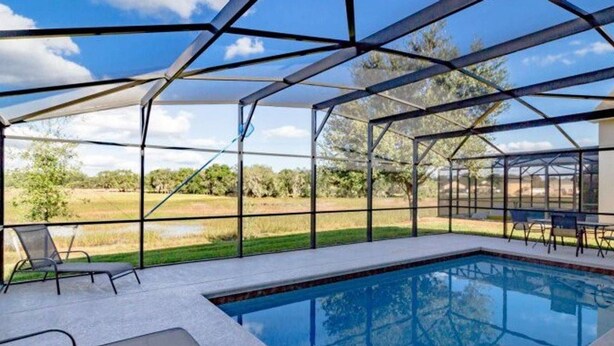 A pool area with a clear view of the surrounding landscape, including trees and open fields. - Marbella South - Lovely 5bd/3.5ba PH #5ms040 (Davenport)