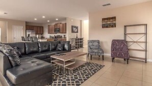 A modern living room with a black leather sofa, a patterned armchair, and a coffee table. - Marbella South - Lovely 5bd/3.5ba PH #5ms040 (Davenport)