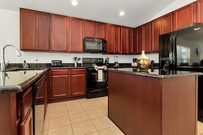 A modern kitchen with wooden cabinets, stainless steel appliances, and a large island.