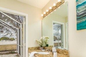 A bathroom with a large mirror, a sink, and a potted plant. - Westridge- Close to Disney-4bd/3ba Home - Rwr4339 (Davenport)