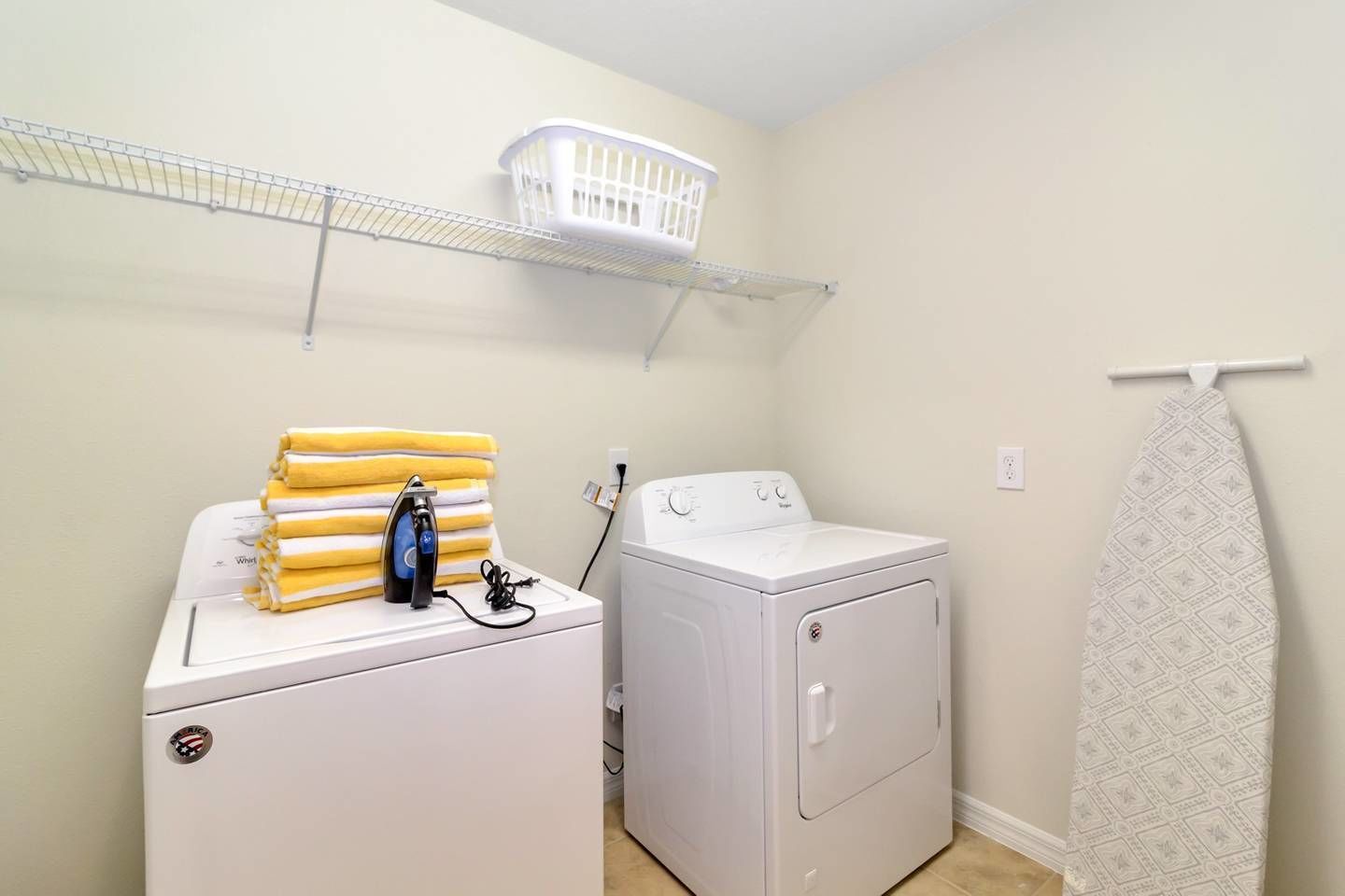 A laundry area with a washing machine, an iron, and a drying rack.