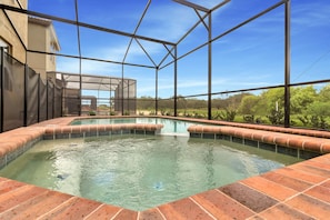 A swimming pool with a clear view of the surrounding landscape, enclosed by a metal frame structure. - Solterra Resort - Lovely 5bd/4ba Pool Home #5st429 (Davenport)