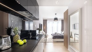 Une cuisine moderne dotée d’un îlot central, d’un coin repas et d’une chambre avec une grande fenêtre.