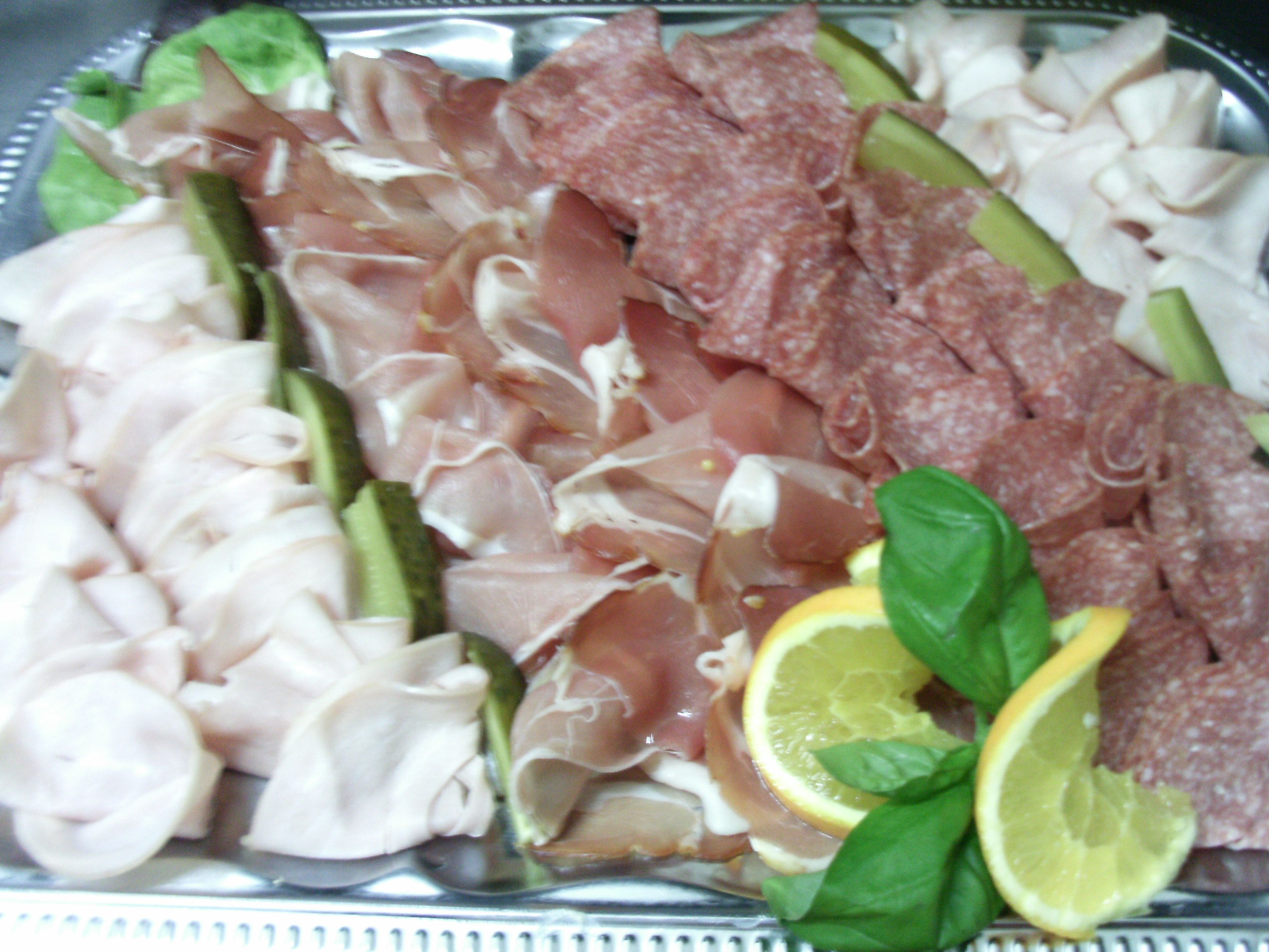 A platter of sliced meats and vegetables.