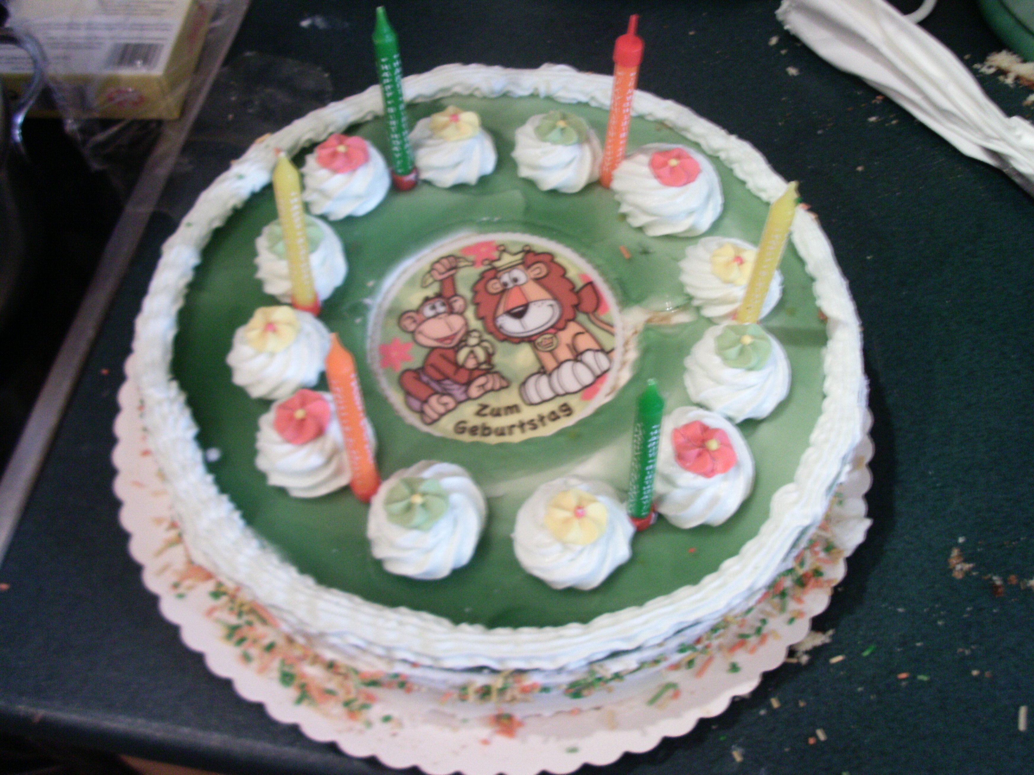 A birthday cake with candles and a monkey design.