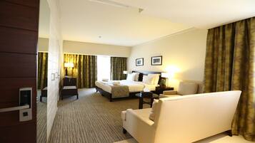Ein Hotelzimmer mit Bett, Sofa, Schreibtisch und Lampe.