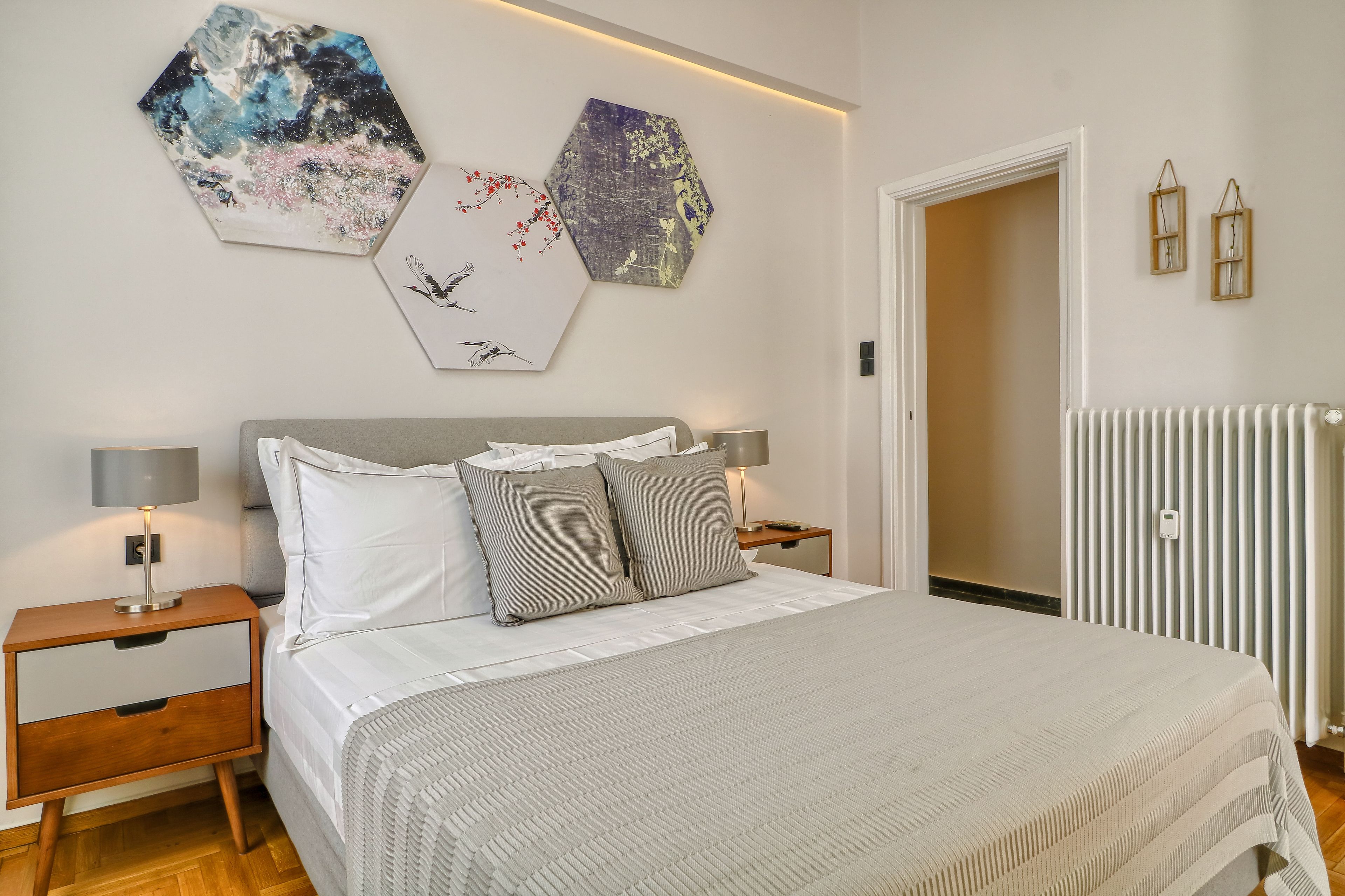 Ein Schlafzimmer mit einem Bett, zwei Nachttischen und Wandbildern.