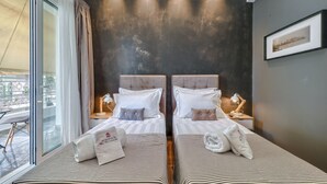 A hotel room with two beds, a large window, and a city view. - Acropolis Plus Penthouse (Athens)