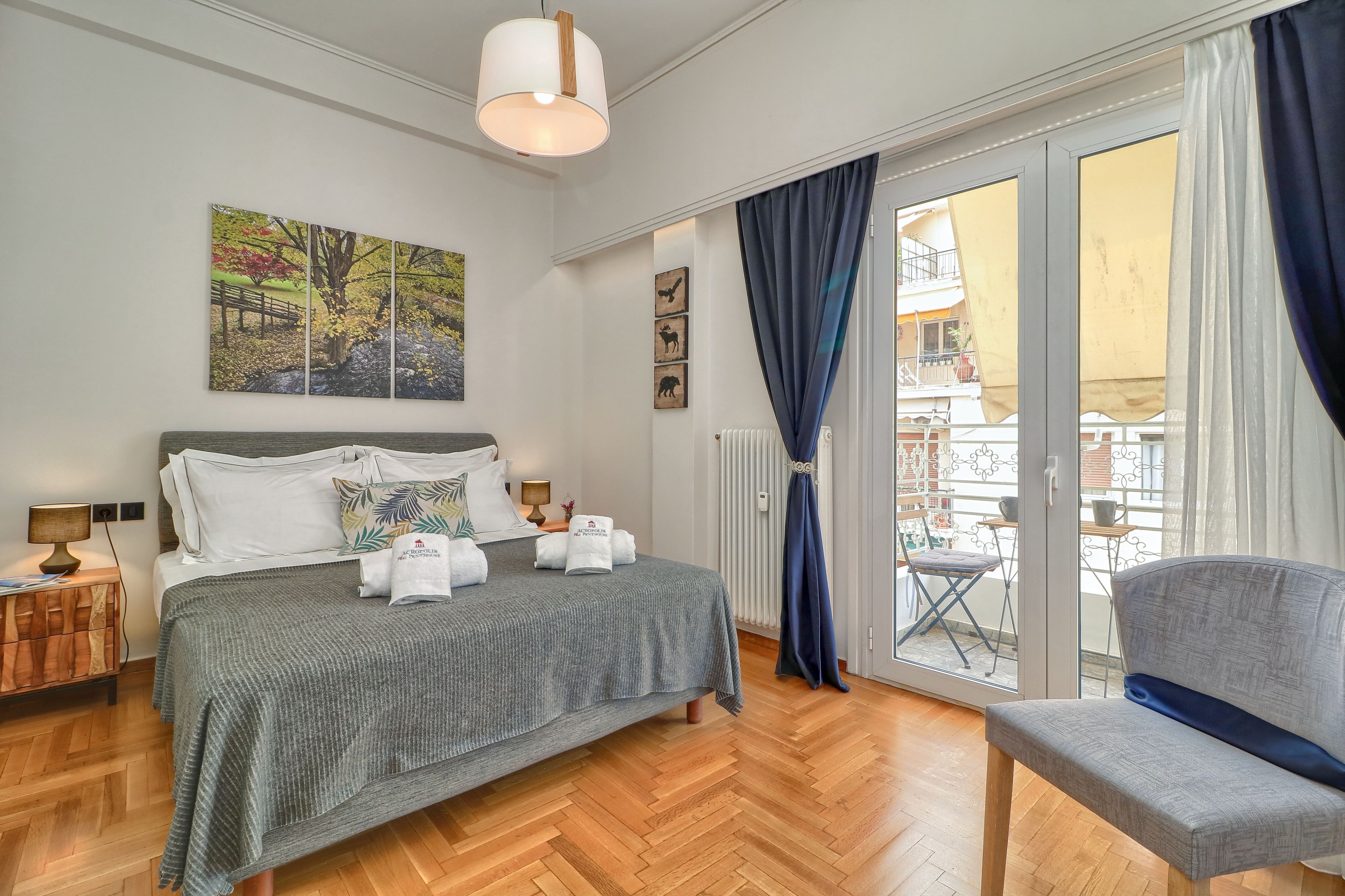 Une chambre d’hôtel avec un lit, une chaise, un tableau et une vue sur le balcon extérieur.