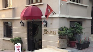 Un edificio con toldo rojo y un letrero que dice "arsuites".