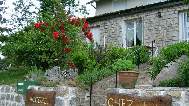 A stone wall with wooden signs reading "ACCUEL" and "CHEZ 101 LOUIS". - Chez Louis - Chambres d'Hôtes (La Canourgue)
