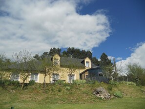 A two-story house with a sloped roof, a chimney, and a small window. - Chez Louis - Chambres d'Hôtes (La Canourgue)