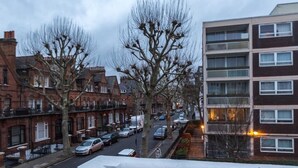 A residential street with terraced houses and a modern apartment building. - Spacious Centrally Located One Bed (London)