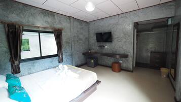 Quarto de hotel moderno com cama, televisão, banheiro e vista para o exterior.