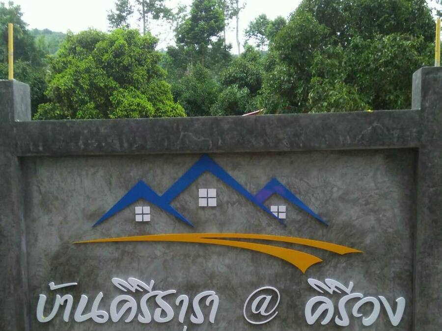 A sign with a house icon and text in a foreign language, indicating a residential area or housing development.
