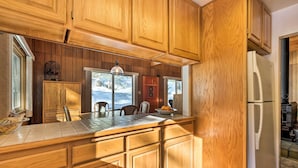 Una cucina con mobili in legno, un piano di lavoro piastrellato e un frigorifero.