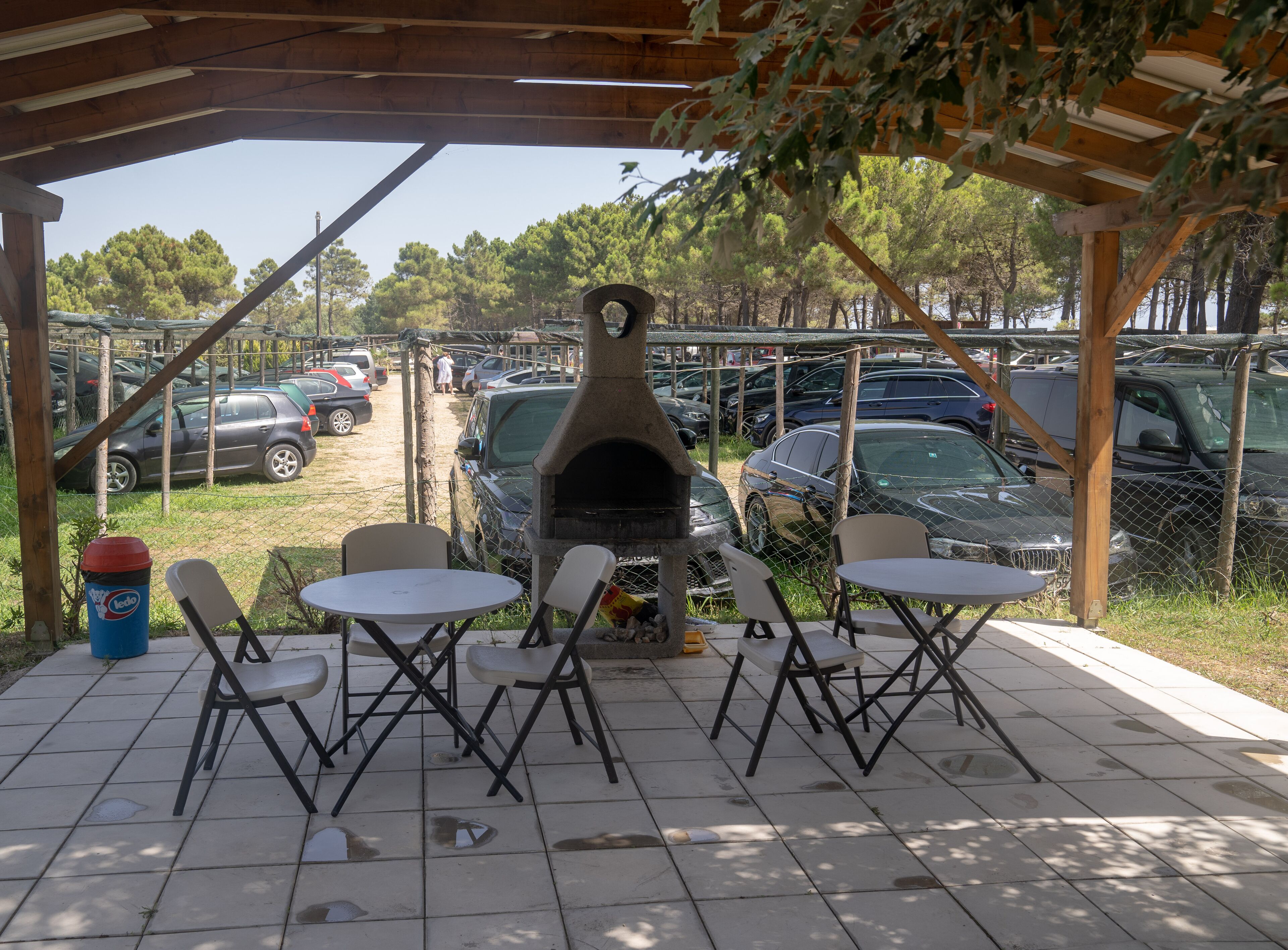 An outdoor patio with a brick floor, metal chairs, and a pizza oven.
