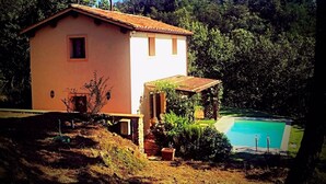 A single-story house with a tiled roof, a small attached structure, and a swimming pool. - villa in the green | street number 2 (uzzano)