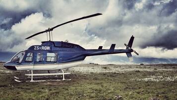 Un helicóptero con matrícula ZS-RGW estacionado en un campo cubierto de hierba.