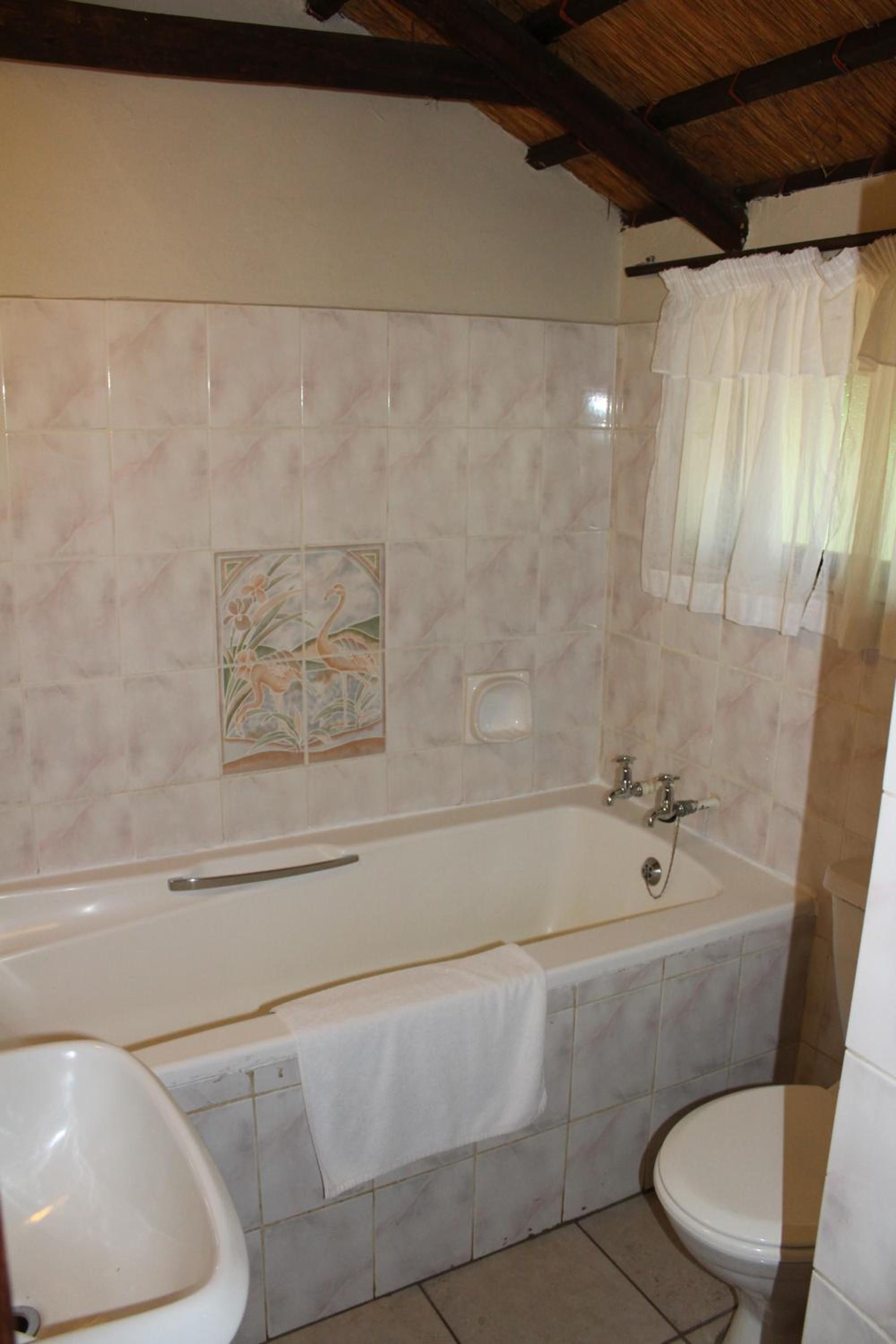 A bathroom with a bathtub, a toilet, and a sink.