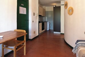 Une cuisine équipée d’un lave-linge, d’une table à manger avec des chaises et d’une porte verte.