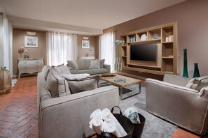 A modern living room with a sofa set, a coffee table, a flat-screen TV, and a fireplace. - Villa Cipriana (Tar-Vabriga)
