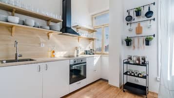 Standaard appartement | Privékeuken | Een koelkast, een microgolfoven, een oven, een kookplaat