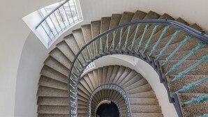 A spiral staircase with a curved railing and a skylight. - Historic Centre APTs by Michal&Friends (Prague)