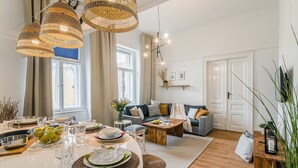 A spacious living area with a dining table set for a meal, a sofa, and a coffee table. - Historic Centre APTs by Michal&Friends (Prague)