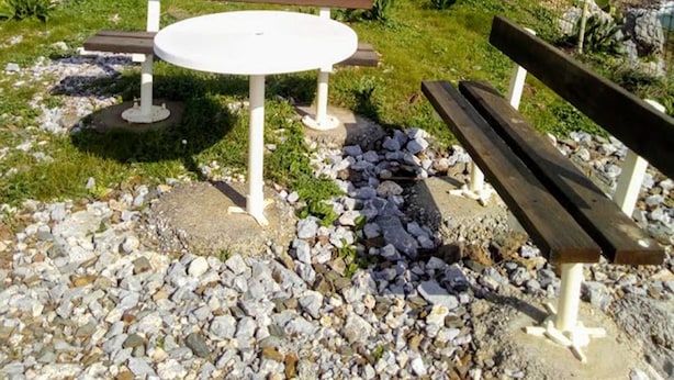 A picnic table and benches in a natural setting with a mountainous backdrop. - Akropolis Studios (Agios Vasileios)