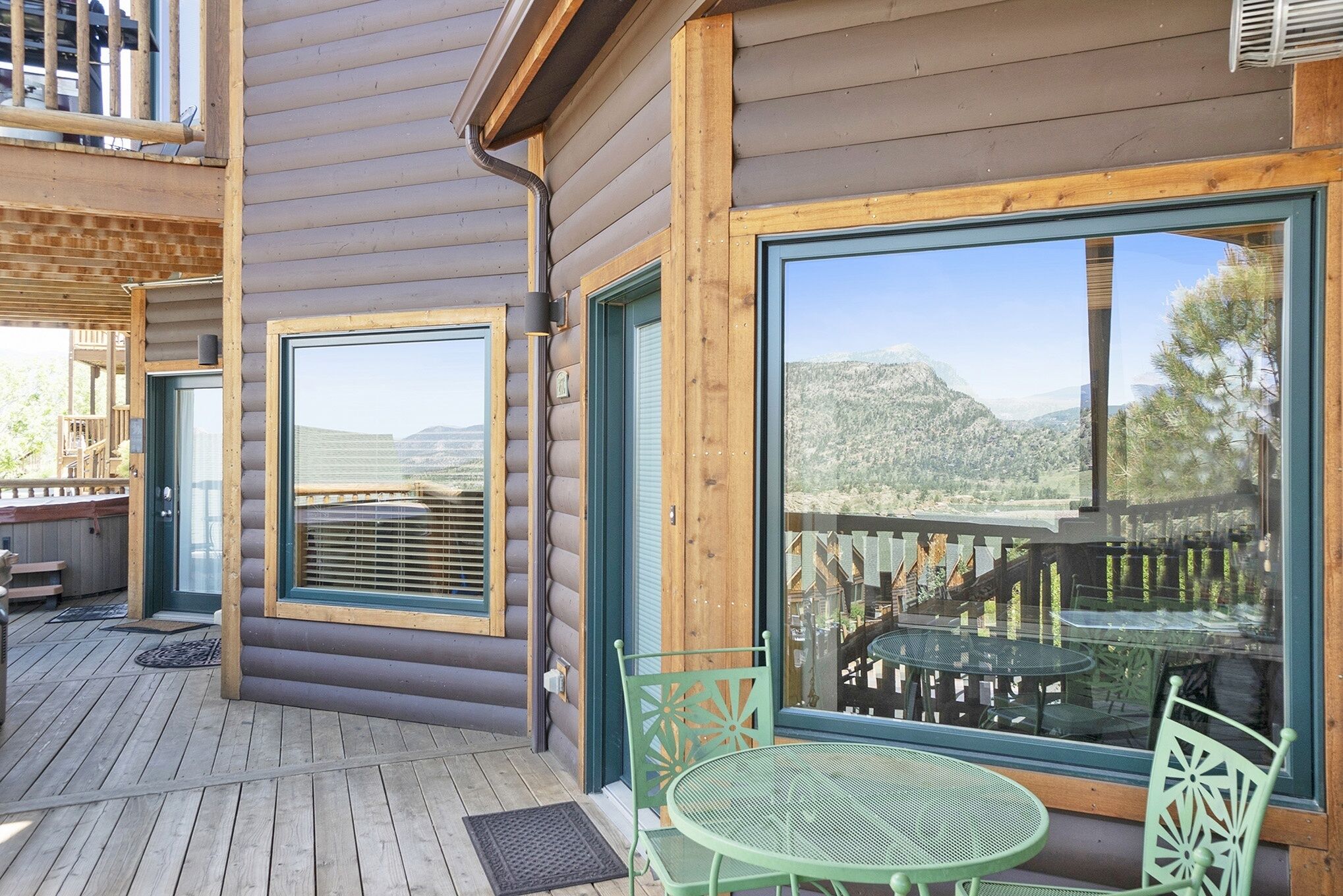 Une cabane en rondins avec une terrasse, une table et des chaises.