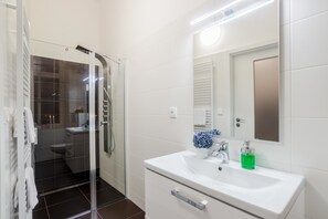 Apartamento standard | Banheiro | Chuveiro, produtos de toalete grátis, secador de cabelo 