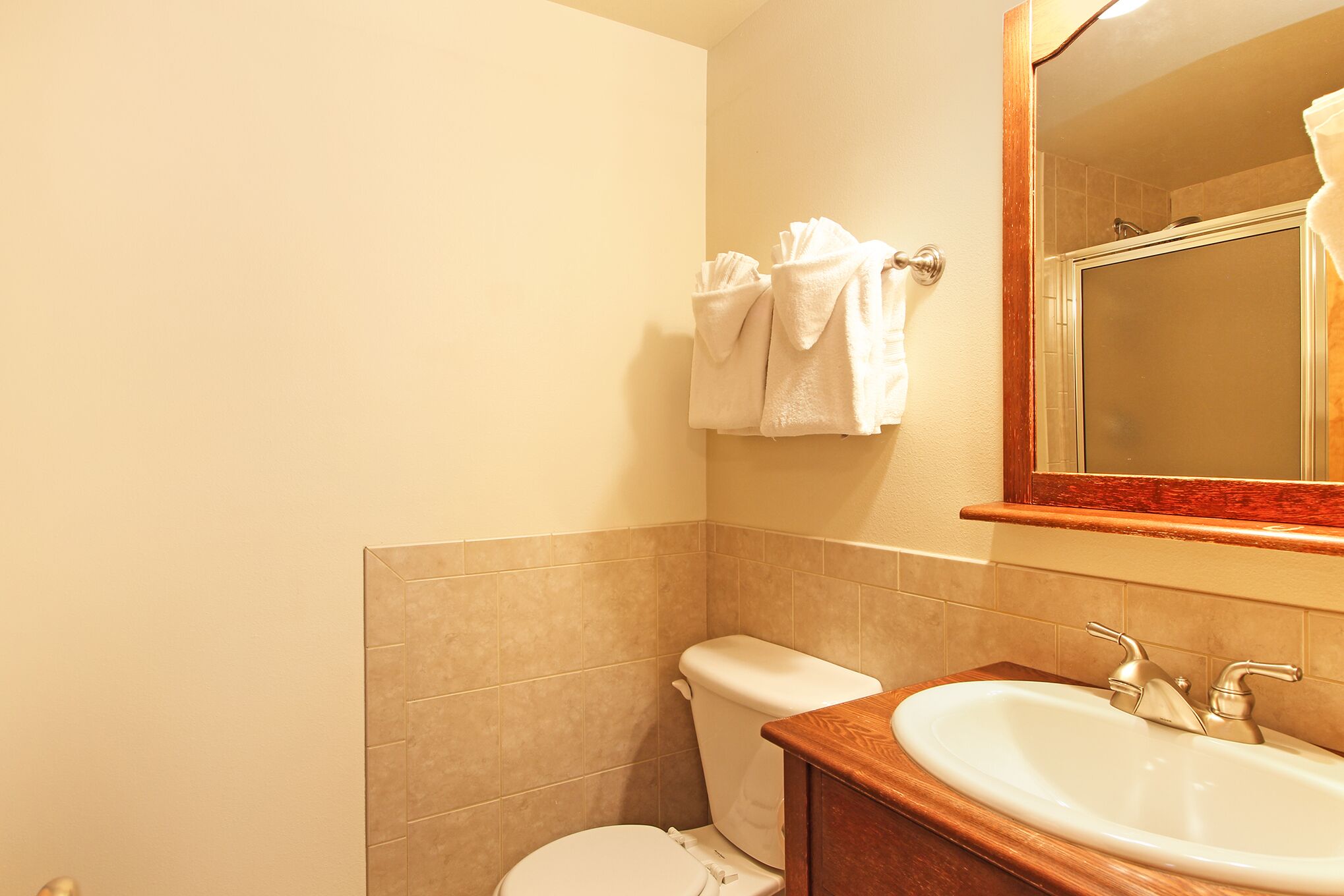 Un baño con inodoro, lavamanos y espejo.