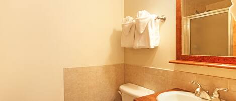 Un baño con inodoro, lavamanos y espejo.