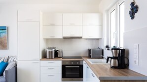 A modern kitchen with white cabinets, a built-in oven, a coffee maker, and a toaster. - Triton Sea View 7 - two bedroom house close to the sandy beach (Asprouliani)